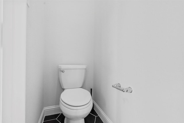 bathroom featuring toilet, tile patterned floors, and baseboards
