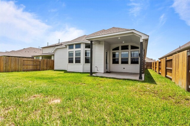 back of property featuring a patio, a fenced backyard, roof with shingles, and a lawn