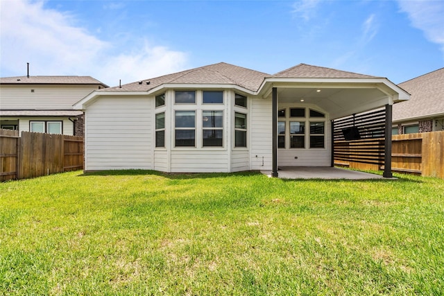 back of property featuring a patio, a yard, a fenced backyard, and roof with shingles