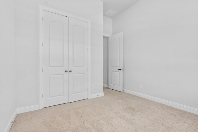 unfurnished bedroom featuring visible vents, a closet, baseboards, and carpet floors