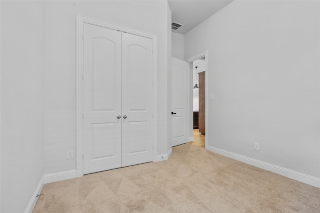 unfurnished bedroom featuring visible vents, a closet, baseboards, and carpet floors