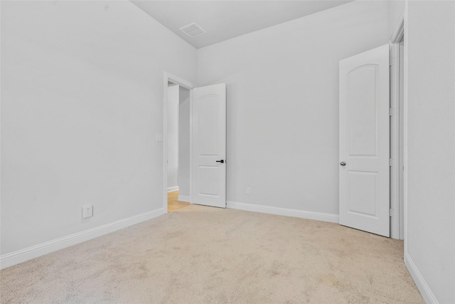 carpeted empty room with visible vents and baseboards