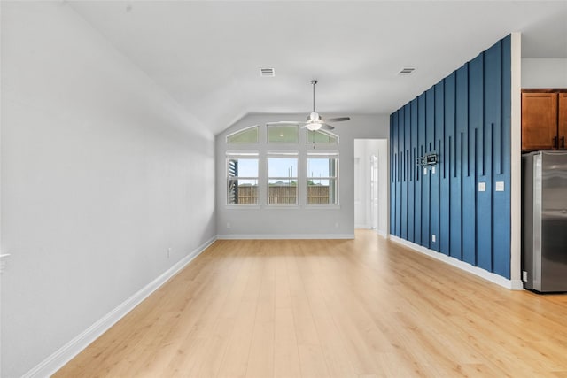 unfurnished living room with visible vents, light wood-type flooring, vaulted ceiling, and ceiling fan