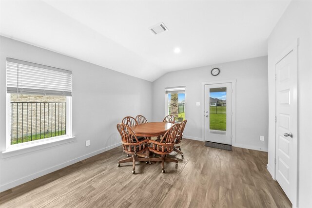 dining area featuring lofted ceiling, wood finished floors, and baseboards