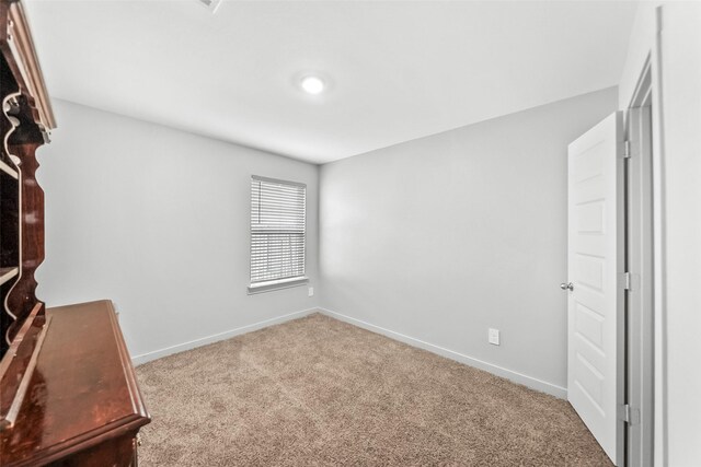 unfurnished office featuring carpet flooring and baseboards