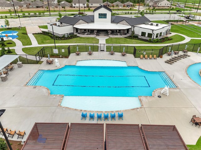 community pool featuring fence, a residential view, and a patio