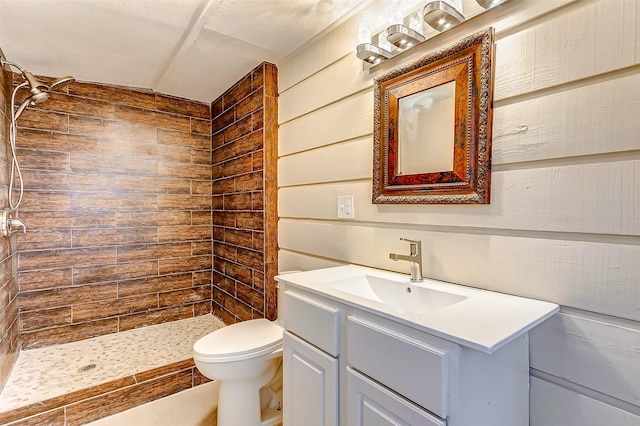 full bathroom with wood walls, toilet, a shower stall, and vanity