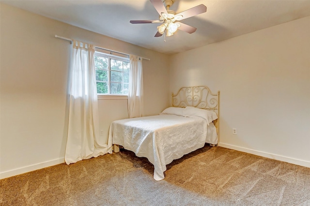 carpeted bedroom featuring baseboards and a ceiling fan