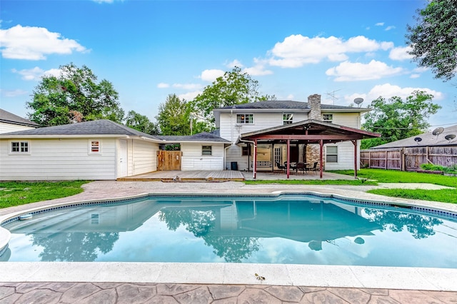 view of swimming pool featuring a wooden deck, a fenced in pool, and fence
