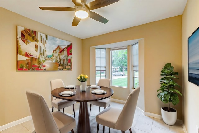 dining room with light tile patterned flooring, baseboards, and a ceiling fan