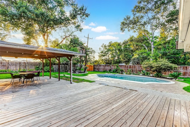 view of swimming pool featuring outdoor dining space, a fenced backyard, a fenced in pool, and a deck