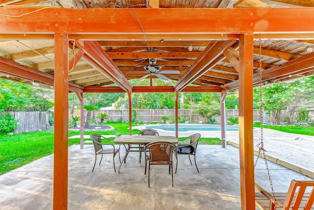 view of patio / terrace with a fenced in pool, a fenced backyard, ceiling fan, and outdoor dining space