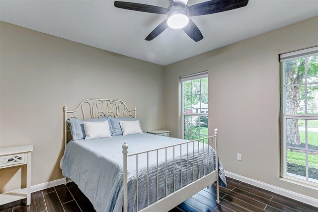 bedroom with baseboards, wood tiled floor, and a ceiling fan