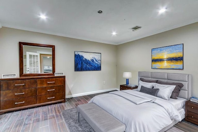 bedroom featuring visible vents, baseboards, wood tiled floor, and ornamental molding