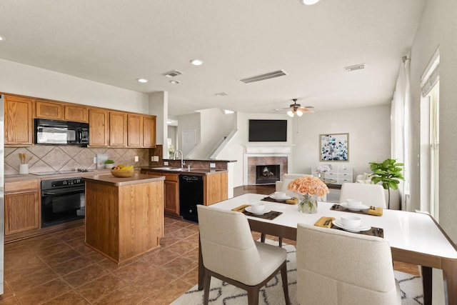 kitchen with visible vents, decorative backsplash, and black appliances