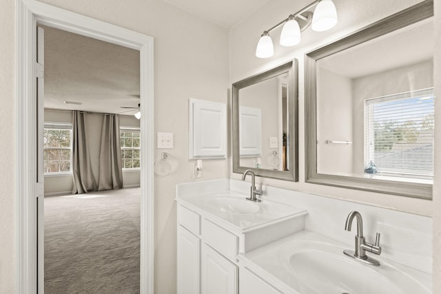bathroom featuring ceiling fan, double vanity, and a sink