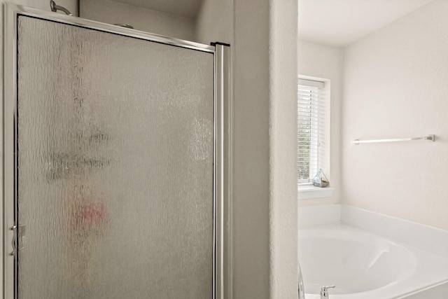full bathroom featuring a garden tub and a stall shower