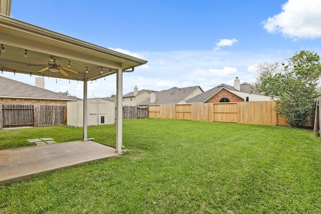 view of yard with an outbuilding, a fenced backyard, and ceiling fan