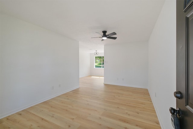 empty room featuring ceiling fan, light wood-style floors, and baseboards
