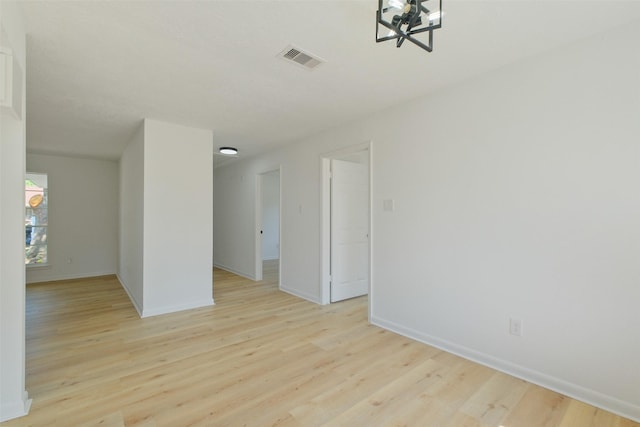 unfurnished room with light wood-style floors, baseboards, and visible vents