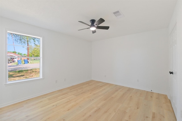 unfurnished room featuring light wood-style floors, baseboards, a ceiling fan, and visible vents