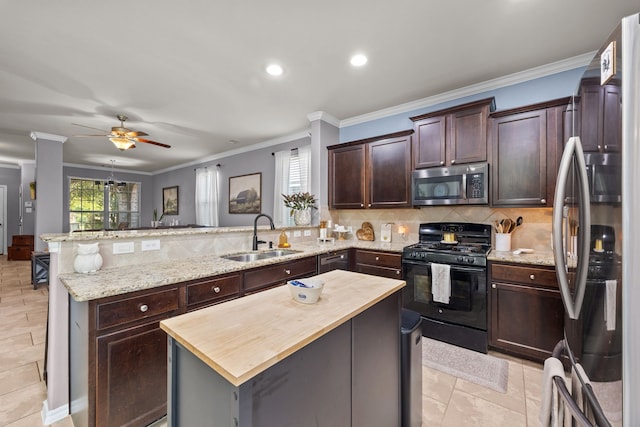 6857 Dogwood Cliff Ln, Dickinson, TX 77539 - kitchen featuring a sink, a peninsula, butcher block counters, stainless steel microwave, and black range with gas stovetop