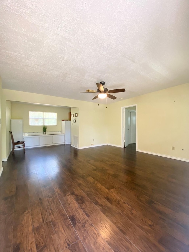 spare room featuring dark wood-type flooring, a textured ceiling, ceiling fan, and visible vents