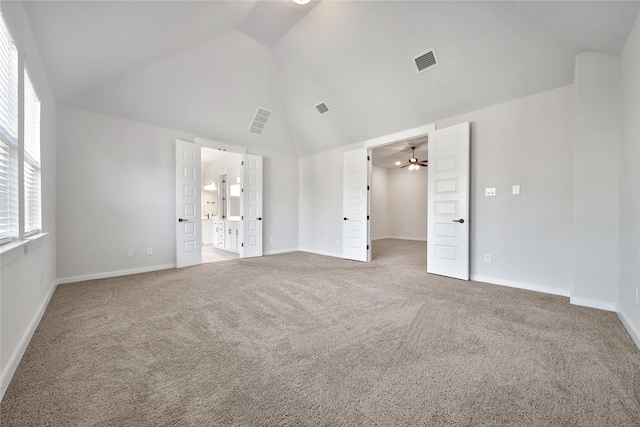 unfurnished bedroom featuring high vaulted ceiling, a walk in closet, visible vents, and carpet floors