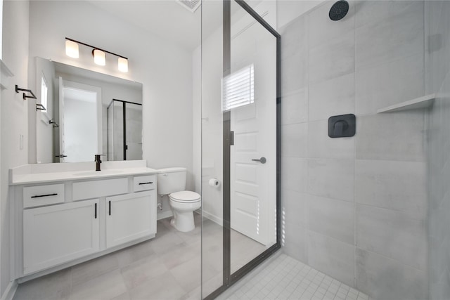 bathroom with vanity, baseboards, a tile shower, and toilet