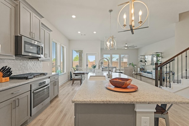 kitchen featuring a sink, appliances with stainless steel finishes, a healthy amount of sunlight, and gray cabinets