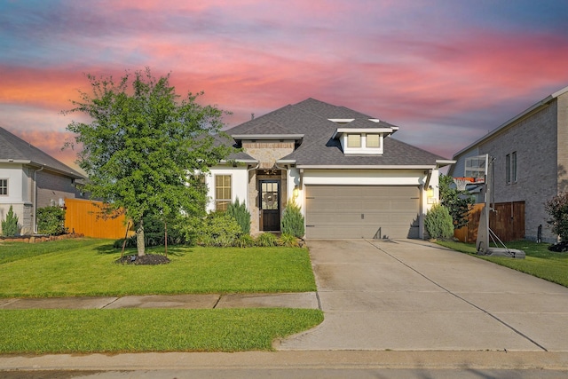 traditional-style house with concrete driveway, a lawn, an attached garage, and stucco siding