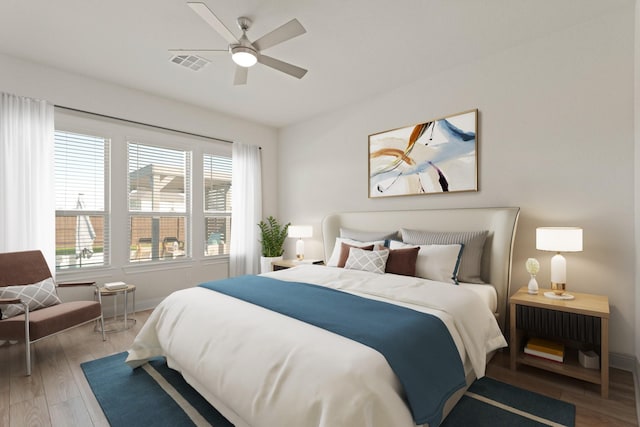 bedroom featuring a ceiling fan, baseboards, visible vents, and wood finished floors