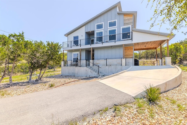 206 Damar Cv, Canyon Lake, TX 78133 - view of front of property with board and batten siding, a balcony, and concrete driveway