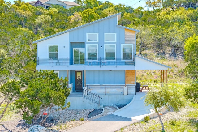 206 Damar Cv, Canyon Lake, TX 78133 - modern home with a carport, a balcony, driveway, and board and batten siding