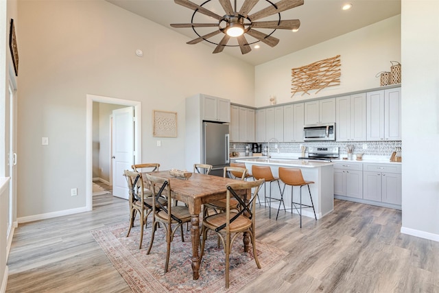206 Damar Cv, Canyon Lake, TX 78133 - dining room with baseboards, recessed lighting, a high ceiling, a ceiling fan, and light wood-style floors