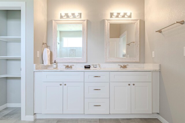 206 Damar Cv, Canyon Lake, TX 78133 - bathroom with double vanity, a sink, and baseboards