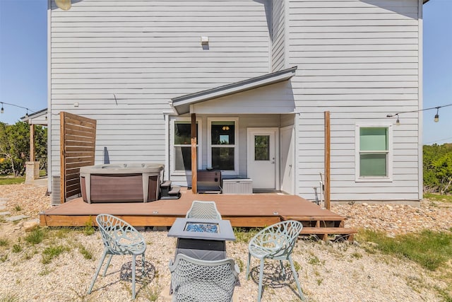 206 Damar Cv, Canyon Lake, TX 78133 - rear view of property with an outdoor fire pit, a deck, and a hot tub