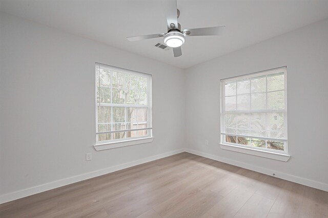 unfurnished room featuring visible vents, baseboards, ceiling fan, and wood finished floors