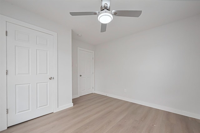 unfurnished bedroom featuring light wood-type flooring, baseboards, and a ceiling fan