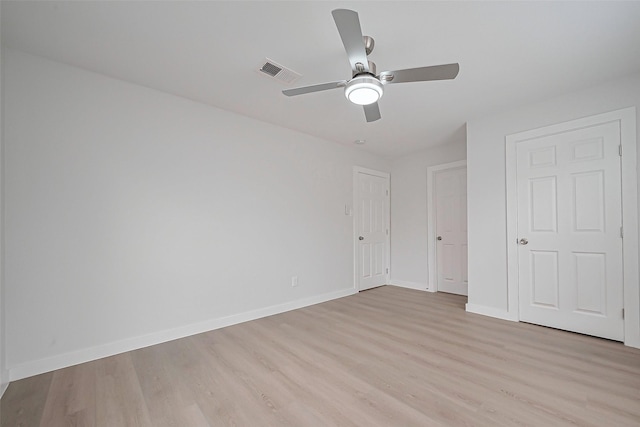 unfurnished bedroom featuring visible vents, baseboards, ceiling fan, and light wood-style floors