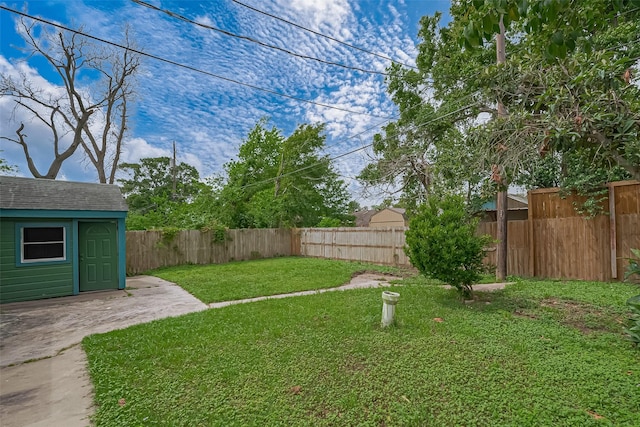 view of yard featuring a fenced backyard, an outbuilding, and a storage unit