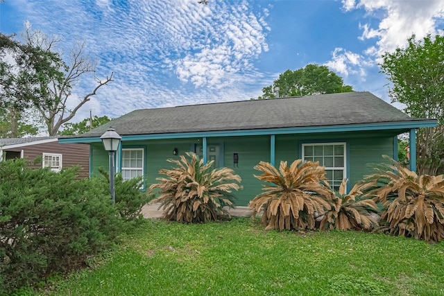 view of property exterior with a shingled roof and a lawn