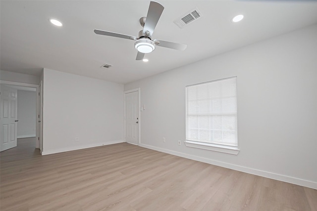 spare room with visible vents, baseboards, a ceiling fan, and light wood finished floors