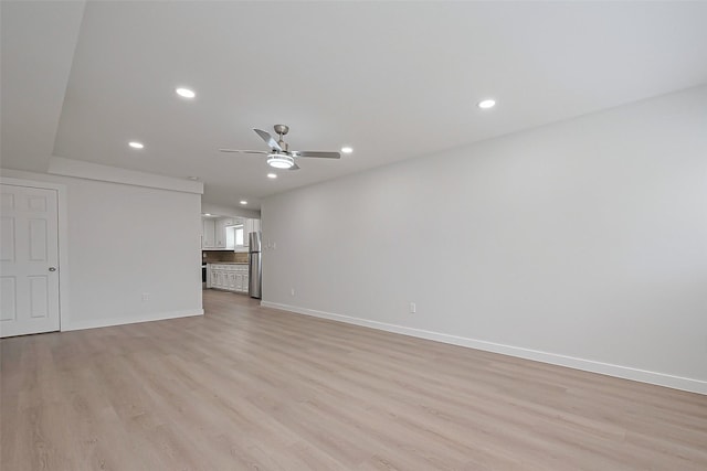 unfurnished living room with light wood-type flooring, baseboards, and a ceiling fan