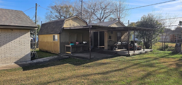 back of property featuring a gambrel roof, a lawn, a patio area, fence, and a shingled roof