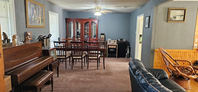 dining room featuring a textured ceiling, visible vents, ceiling fan, and carpet