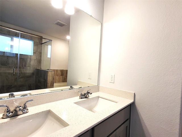 full bath featuring a stall shower, double vanity, a sink, and visible vents
