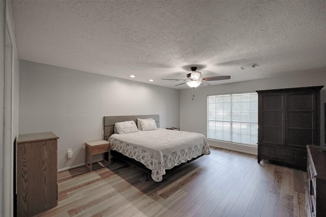 bedroom featuring visible vents, ceiling fan, a textured ceiling, recessed lighting, and light wood-style flooring