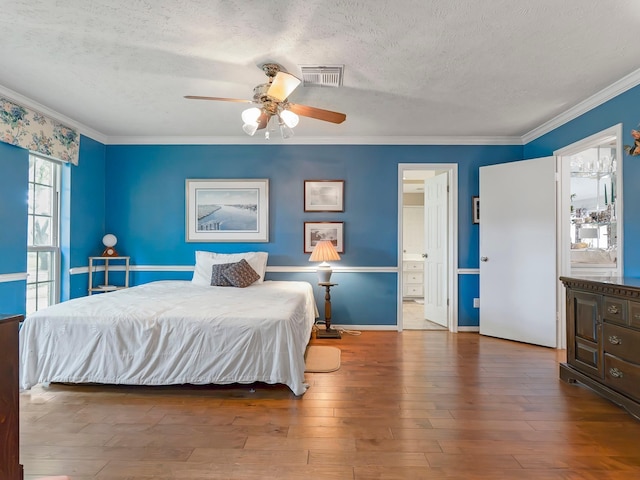 bedroom featuring ornamental molding, a textured ceiling, and hardwood / wood-style floors