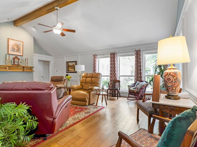 living room featuring lofted ceiling with beams, wood finished floors, and ceiling fan